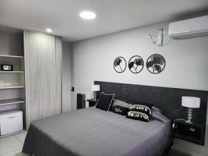 维拉卡洛斯帕兹Hotel El Paraiso Boutique的卧室配有一张床,墙上有三面镜子