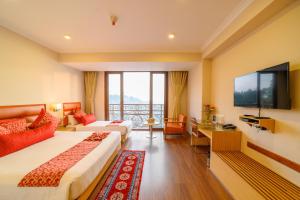 een hotelkamer met twee bedden en een flatscreen-tv bij Sinclairs Gangtok in Gangtok