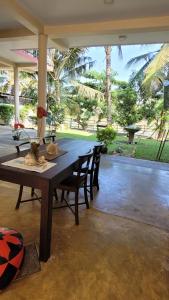 a large wooden table with chairs in a patio at Pelli Riverine in Weligama
