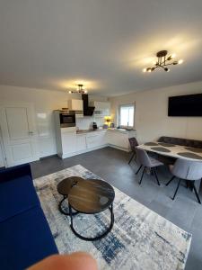 a kitchen and living room with a table and chairs at FeWo's Weinbergblick Wintrich by Brauneberger Hof in Wintrich +41 photos