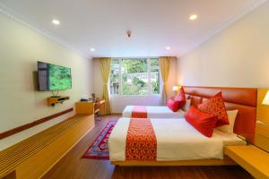 een slaapkamer met twee bedden en een flatscreen-tv bij Sinclairs Gangtok in Gangtok +82 foto's