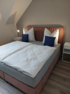 a bedroom with a large bed with blue pillows at FeWo's Weinbergblick Wintrich by Brauneberger Hof in Wintrich