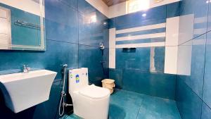 un bagno bianco e blu con servizi igienici e lavandino di Elegant Mountain Resort a Kalpetta Altre 32 foto