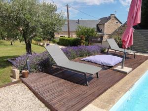 a deck with two chairs and a bed next to a pool at Lili de La LisaThi in Cruéjouls