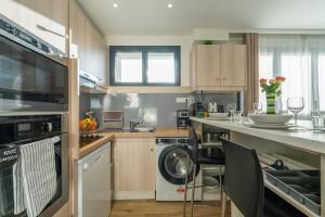 eine Küche mit Waschmaschine und Geschirrspüler in der Unterkunft Les Coteaux 4 - Avec jardin à Argenteuil in Argenteuil + 4 Fotos