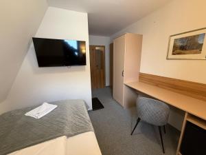 a hotel room with a bed and a desk with a television at Rozetka Białka in Białka Tatrzanska