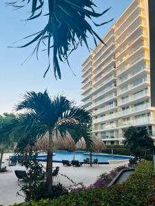 Un gran edificio con una palmera delante. en Torres del Mar Santa Marta, en Santa Marta