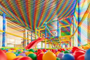 Promocje Amber Park Spa في نيخوجة: غرفة بها شريحة حمراء والكثير من الكرات