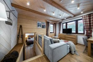 a living room with a couch and a tv at Apartamenty Kuźnice 13 in Zakopane