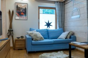 a blue couch in a living room with a window at Apartamenty Kuźnice 13 in Zakopane