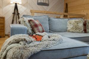 a blue couch with a blanket and glasses on it at Apartamenty Kuźnice 13 in Zakopane +51 photos