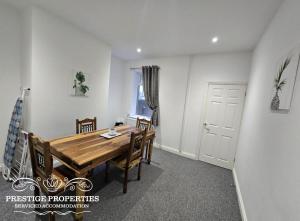 a dining room with a wooden table and chairs at 52 Wordsworth Street by Prestige Properties SA in Barrow in Furness