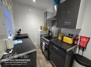 a kitchen with a black counter top and a stove at 52 Wordsworth Street by Prestige Properties SA in Barrow in Furness
