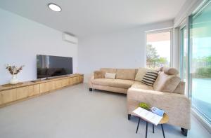 een woonkamer met een bank en een tv bij Villa I Residence in Punat