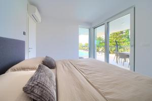 een slaapkamer met een bed en uitzicht op een patio bij Villa I Residence in Punat +96 foto's