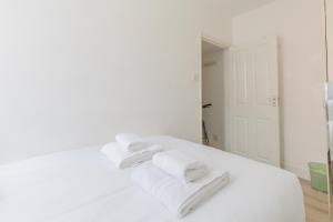 a white bedroom with white towels on a bed at Central 1BD Flat 6 minutes to Old Street station in London