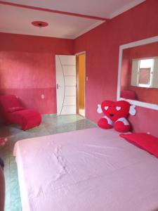a red bedroom with a bed with a red teddy bear at Aluguel casa mobiliada cop30 - Belém - Pará in Belém