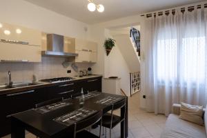 a kitchen with a table with chairs and a counter top at Casa Lulù in Chioggia