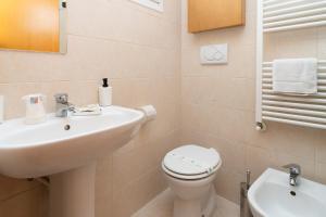 Un baño blanco con lavabo e inodoro. en Casa Lulù, en Chioggia 17 fotos más