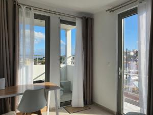 a dining room with a table and glass windows at Hi Hellas 4 in Artemida