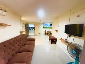 a living room with a couch and a flat screen tv at Archary Lanta Apartment in Ko Lanta