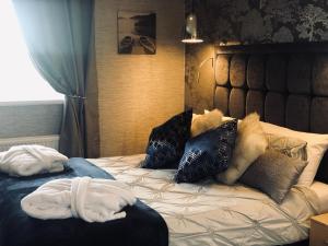 a bed with a bunch of pillows on it at Briardene in Blackpool +41 photos