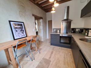 a kitchen with a wooden table and a counter top at Hôtel des arts - Gîte Littérature dans le Perche - Spa in Rémalard