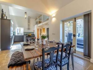 a dining room with a table and chairs and a kitchen at Stunning Barn with Hot Tub on a Secluded Farm in Eckington