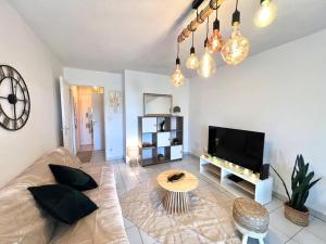 a living room with a couch and a table at Le Montaigne - Parking inclus, Tramway et MEET in Blagnac