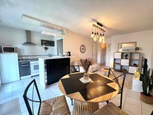 una cucina e un soggiorno con tavolo e sedie di Le Montaigne - Parking inclus, Tramway et MEET a Blagnac Altre 18 foto