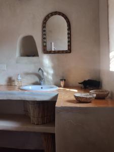 a bathroom with a sink and a mirror at Riad ysabil in Amersal