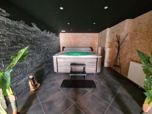a room with a bed in a brick wall at Hôtel des arts - Gîte Littérature dans le Perche - Spa in Rémalard