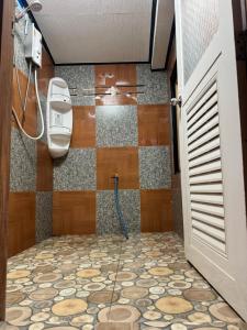 a bathroom with a shower with a tile floor at Archary Lanta Apartment in Ko Lanta