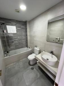 a bathroom with a toilet and a sink and a bath tub at San Mateo Loft in Tarifa