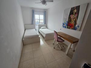 Pokój z biurkiem, łóżkiem i stołem w obiekcie Amazing ocean view apartment w Corralejo
