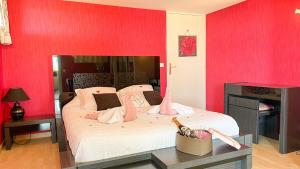 a bedroom with a large bed with red walls at Loft avec jacuzzi et sauna in Ferrières-la-Verrerie