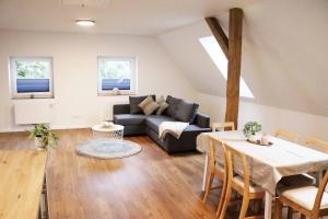 a living room with a couch and a table at Ferienwohnungen Kutschenmeyer in Schneverdingen