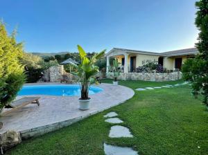 a yard with a swimming pool and a house at Oasi Muru Idda in Budoni