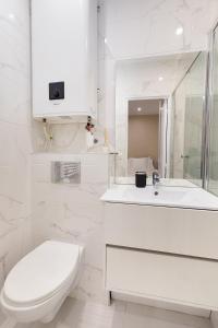 パリにあるLasuite Montbrunのトイレと洗面台を備えた白いバスルーム