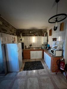 a kitchen with a white refrigerator and a sink at Casa Paraíso in Ribeira de Pena