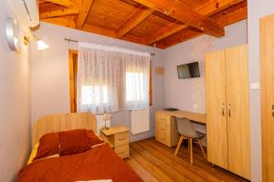 a bedroom with a bed and a desk with a computer at Tisza Panzió és Apartman in Tiszaújváros