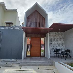 a house with a wooden door and a patio at 3 Bedroom House Near Grand Batam Mall in Bagam