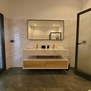 un baño con lavabo y espejo en Villa à louer, en Saly Portudal