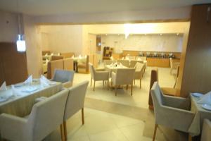 a dining room with tables and chairs in a restaurant at Momona Hotel in Addis Ababa