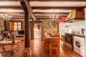 Una cocina y un comedor con mesa y sillas. en Apartamento Juntana 1, en Villacarriedo