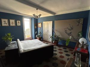 a bedroom with a bed and blue walls and a window at Postcard view 3 minutes walk from the lake in Menaggio