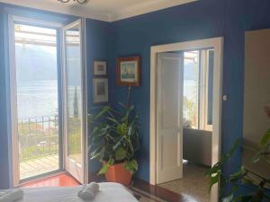 a bedroom with a blue wall with a potted plant at Postcard view 3 minutes walk from the lake in Menaggio