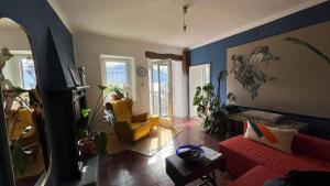 a living room with a red couch and a chair at Postcard view 3 minutes walk from the lake in Menaggio