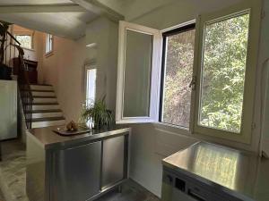 a large living room with two windows and a staircase at Postcard view 3 minutes walk from the lake in Menaggio