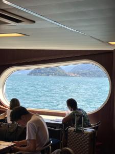 a group of people sitting on a train looking at the water at Postcard view 3 minutes walk from the lake in Menaggio